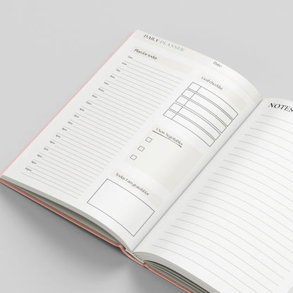 An open daily planner notebook showing lined pages with sections for a daily planner, notes, and a to-do list, photographed on a light gray background.