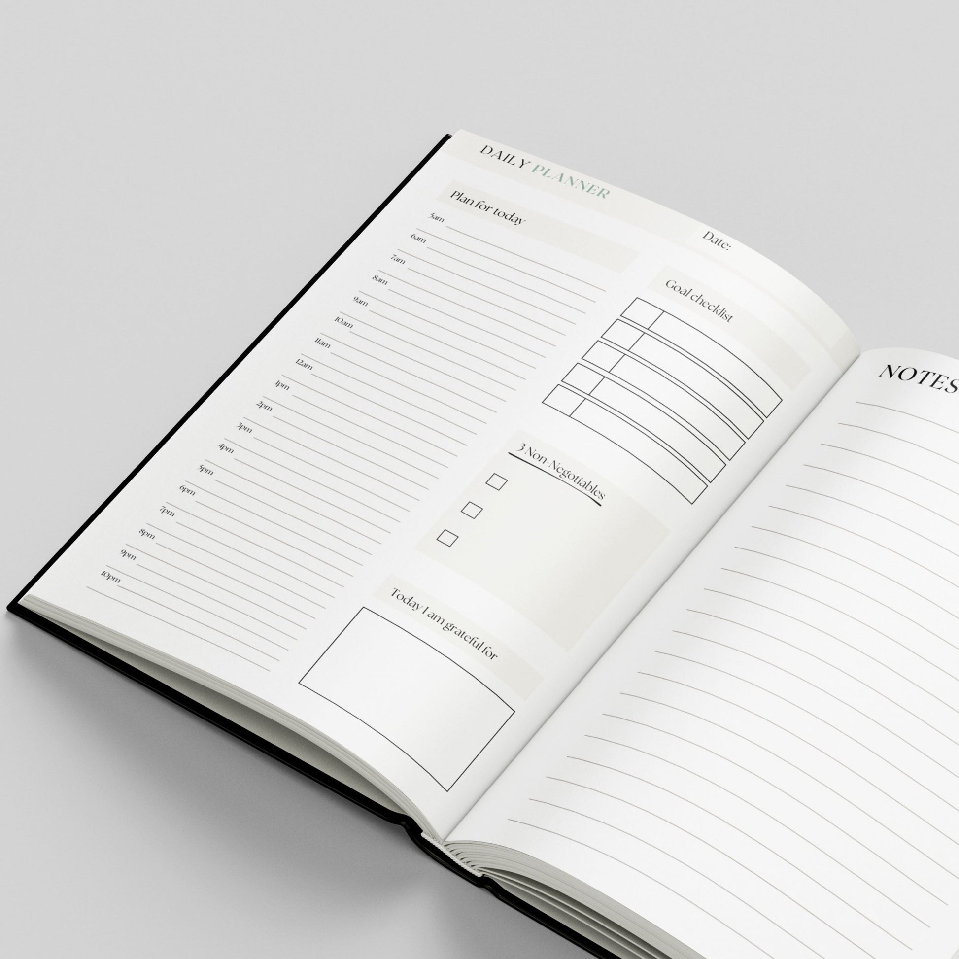 An open hardcover daily planner notebook on a light grey background, showing lined pages with sections for a daily planner, goal checklist, notes, and task boxes.