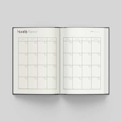 Open productivity planner showing a monthly planning calendar with weekday headings and spacious boxes for organising appointments and goals.