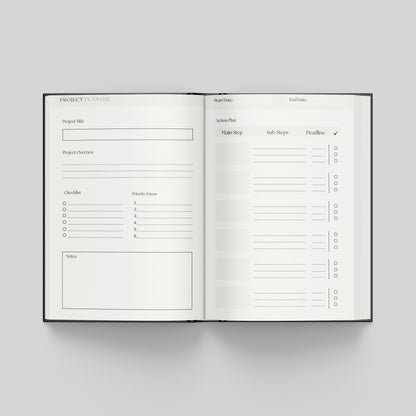 An open hardcover project planner book displayed flat against a neutral light grey background. The pages are white with black printed text and lines for tracking project details, milestones, and tasks.