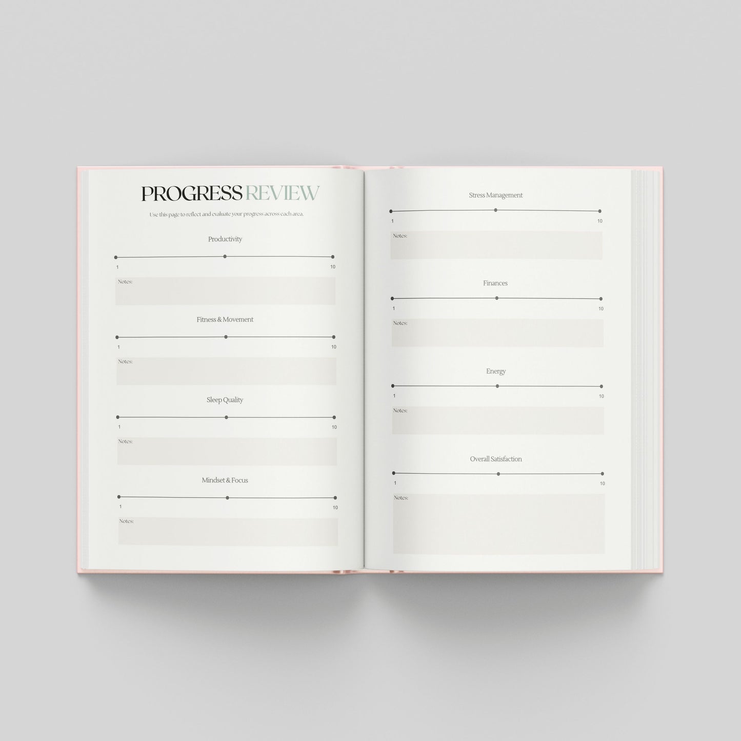 An open planner or notebook spread on a light grey background, showing two white pages with printed review sections to assess how far you've come.