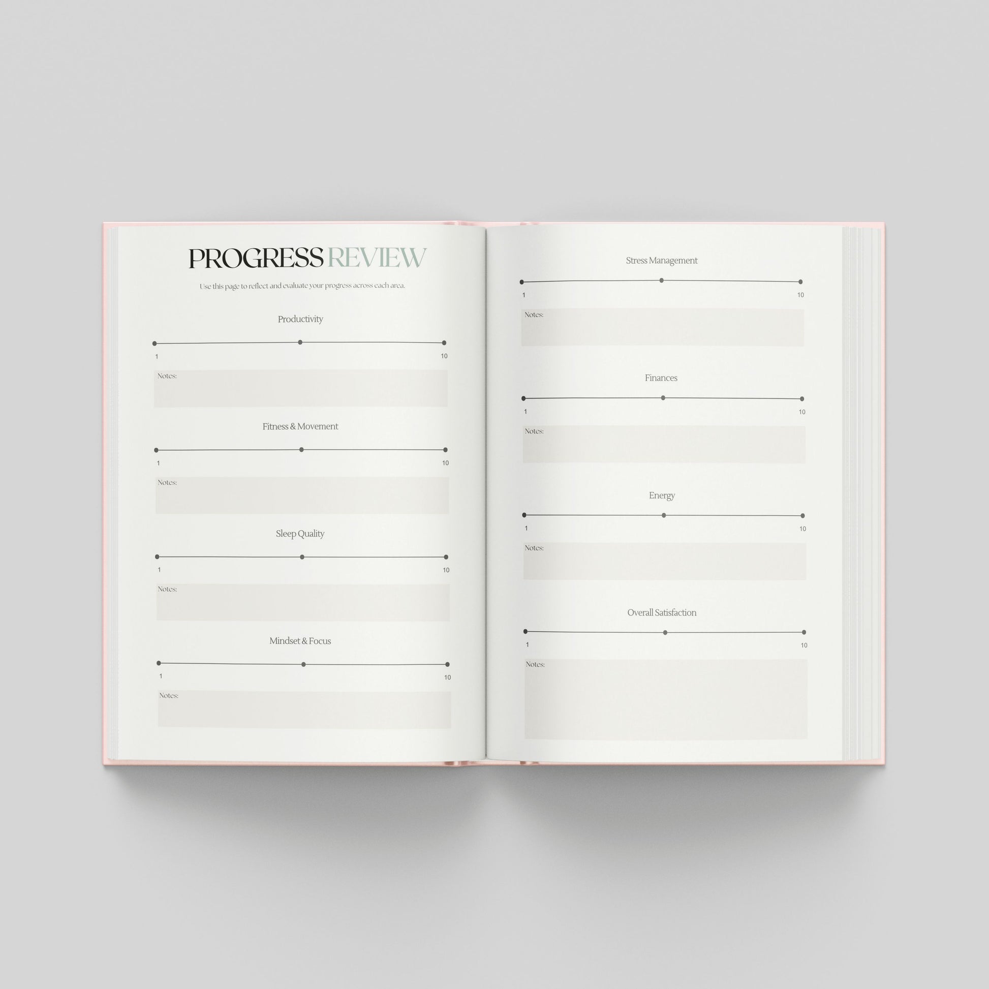 An open planner or notebook spread on a light grey background, showing two white pages with printed review sections to assess how far you've come.